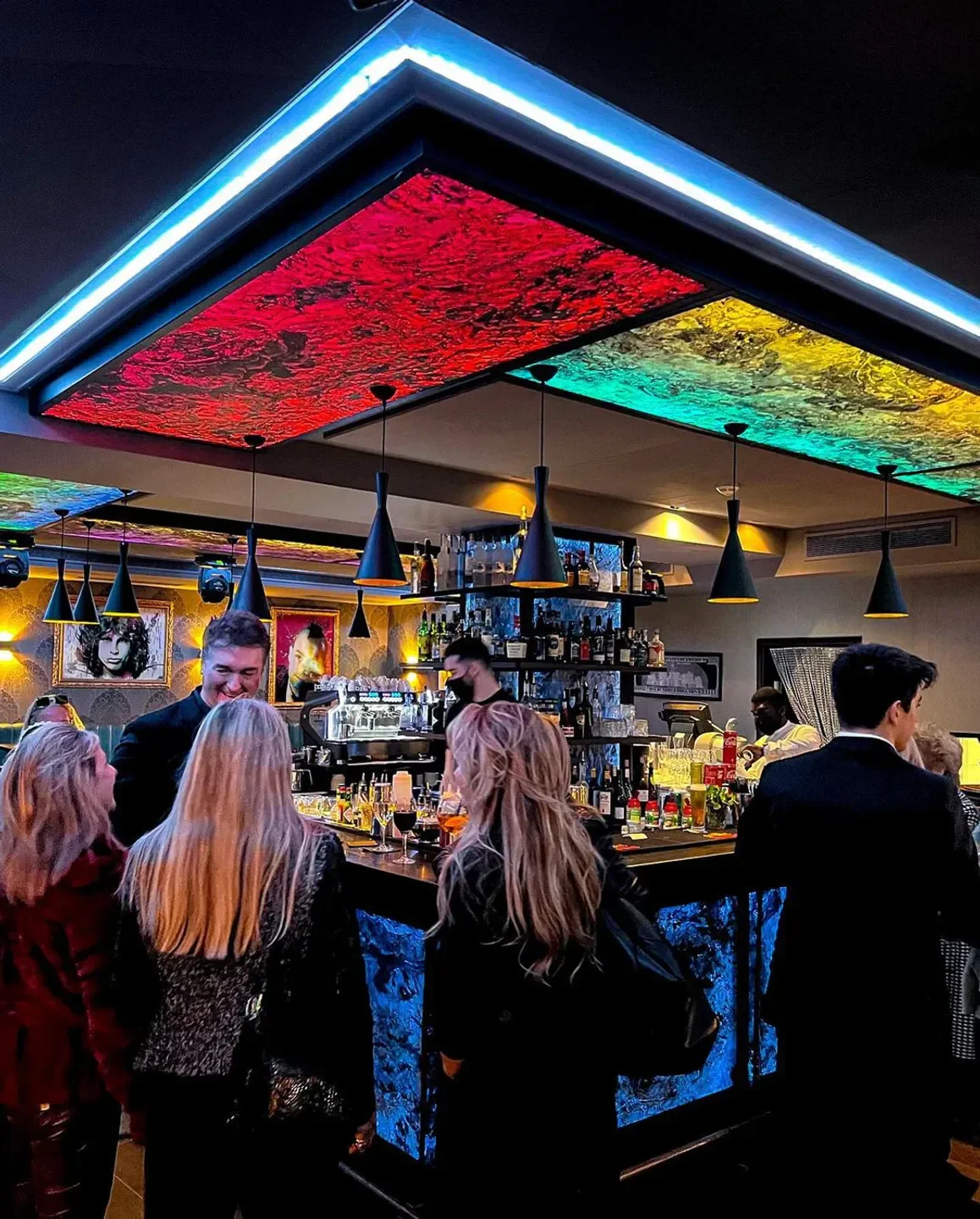 Interior of Bfire restaurant in Courchevel with colorful ceiling and patrons at the bar.