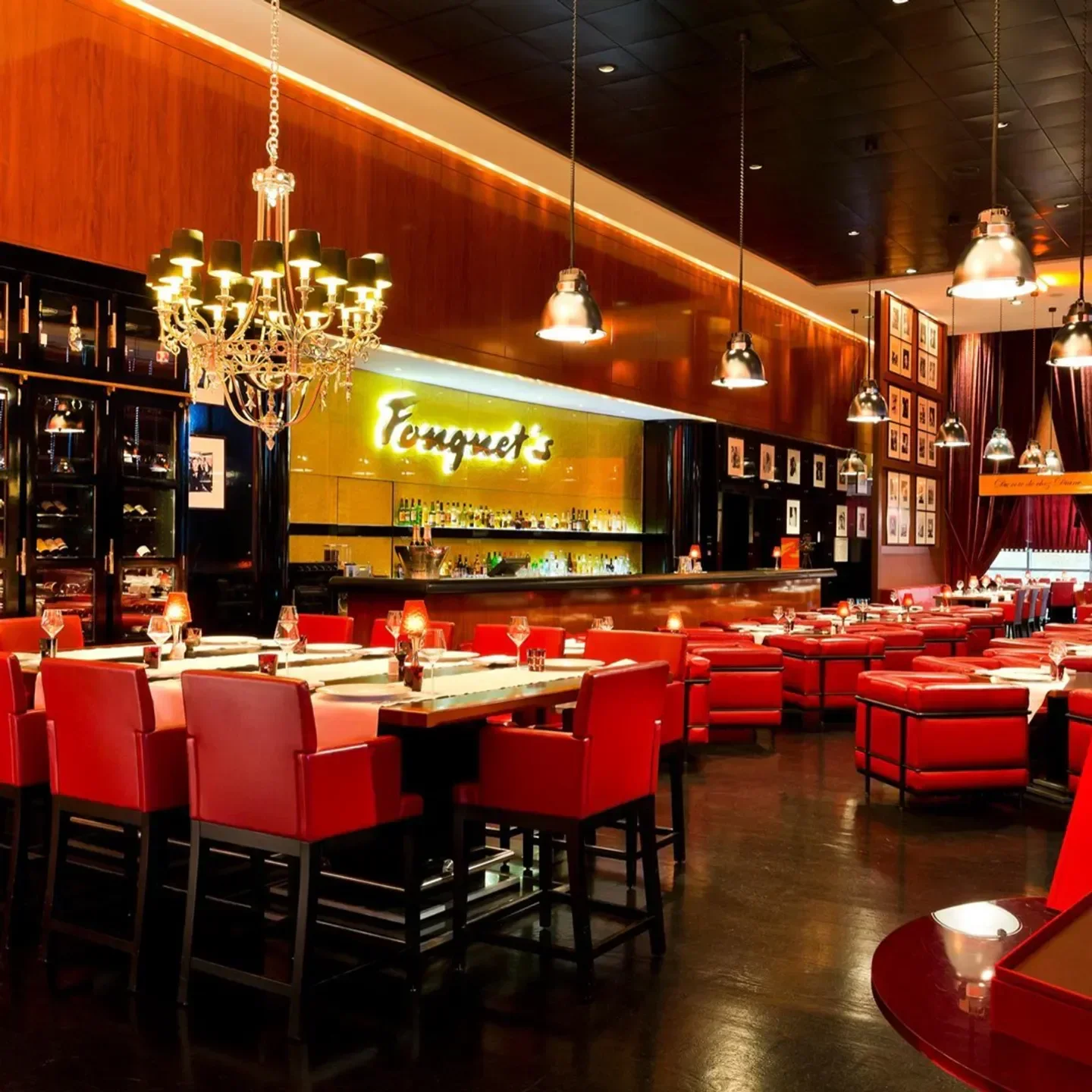 Interior of Fouquet's in Courchevel with elegant red seating and a bar in the background.