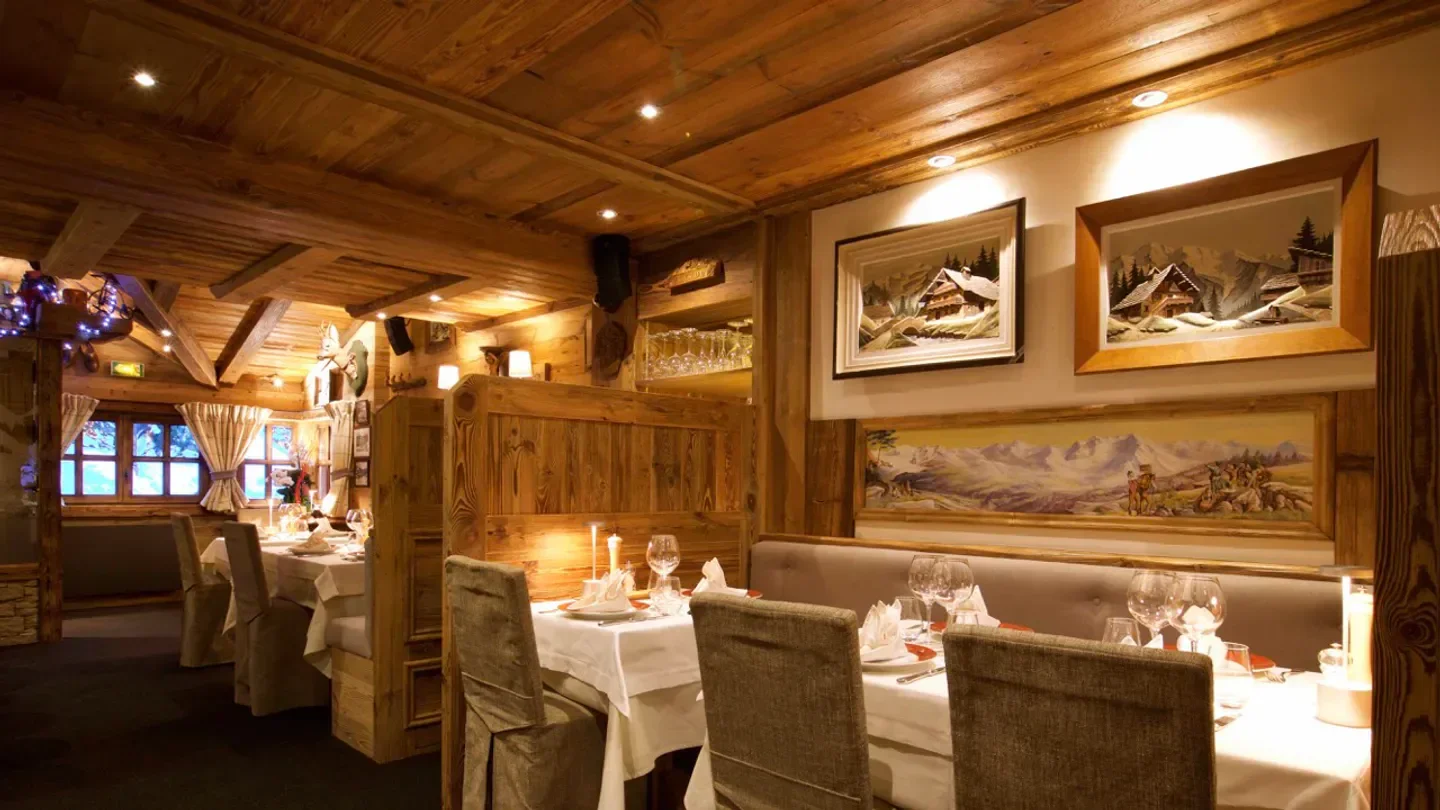 Cozy dining room at La Saulire restaurant in Courchevel, with wooden decor and artwork