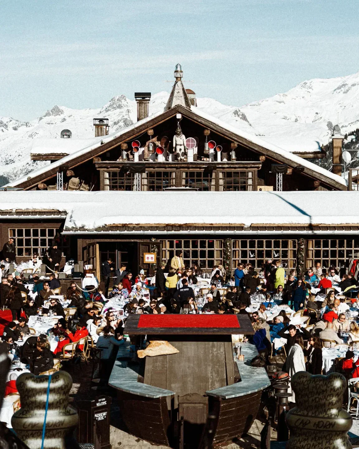 Outdoor dining at Le Cap Horn in Courchevel, a luxury venue surrounded by snowy mountains
